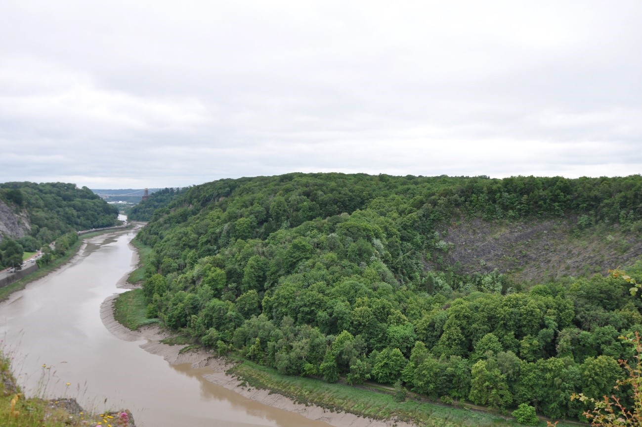 View south-west towards the steep wooded slopes with exposed rock faces.